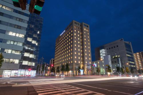 een hoog gebouw in een stadsstraat 's nachts bij President Hotel Mito in Mito