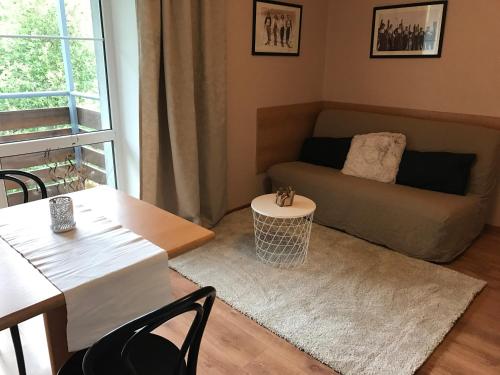 sala de estar con sofá y mesa en Apartmány Gryf Harrachov, en Harrachov