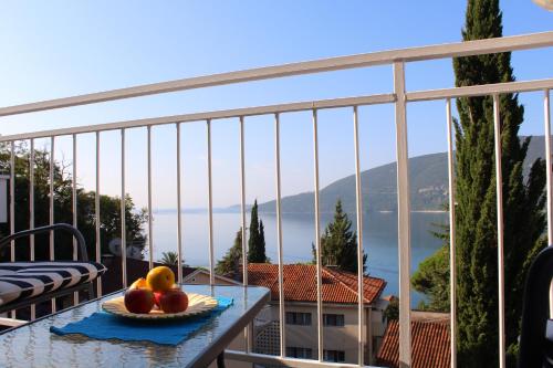 un plato de fruta en una mesa en un balcón en Guest House Tomanovic, en Herceg-Novi