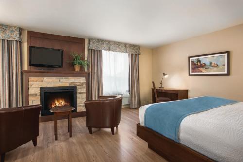 ein Hotelzimmer mit einem Bett und einem Kamin in der Unterkunft Days Inn by Wyndham Levis in Lévis