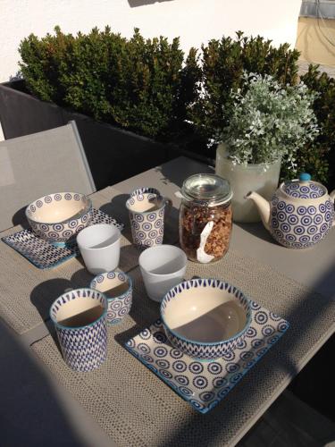 een tafel met blauwe en witte kopjes en kommen erop bij Idées Déco At Home in Verneuil-sur-Seine