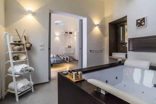 a bathroom with a large tub and a bedroom at Elle Suite in Lecce