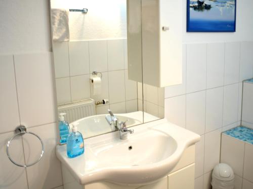 bagno bianco con lavandino e specchio di Gästehaus Jägerstüble a Neckarsulm