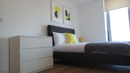 een slaapkamer met een zwart-wit bed en een dressoir bij Quay Apartments in Manchester