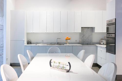 een witte keuken met een witte tafel en witte stoelen bij La Maison Blanche in Beaune