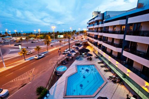 budynek z basenem obok ulicy w obiekcie Aquarios Praia Hotel w mieście Aracaju