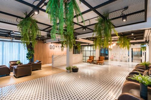 a lobby with chairs and potted plants at Marwin Villa in Bangkok