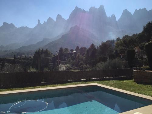 une piscine avec une montagne en arrière-plan dans l'établissement Montserrat La Calsina, à Monistrol de Montserrat