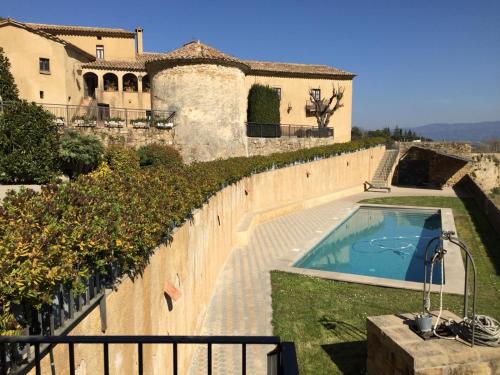 une maison avec une piscine à côté d'une clôture dans l'établissement Montserrat La Calsina, à Monistrol de Montserrat