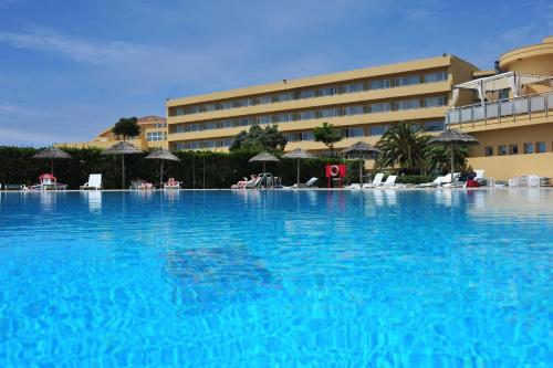 uma grande piscina em frente a um hotel em Axis Ofir Beach Resort Hotel em Esposende