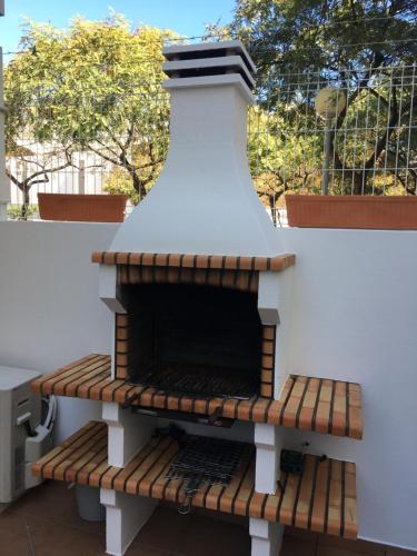 una parrilla de barbacoa sentada en un banco junto a una pared en Ria Apartments, en Olhão