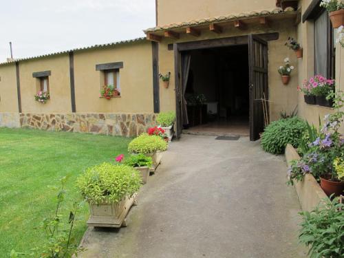 una porta per una casa con dei fiori in un cortile di Albergue San Pelayo a Villarente