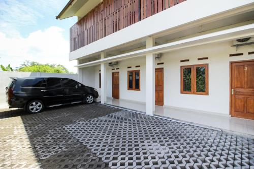 une camionnette noire garée devant une maison dans l'établissement Griya Izzara Guest House Syariah, à Sleman