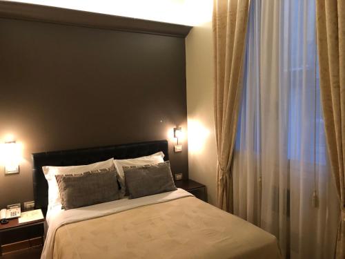 - une chambre avec un lit avec deux oreillers et une fenêtre dans l'établissement Albergo al Tiepolo, à Venise