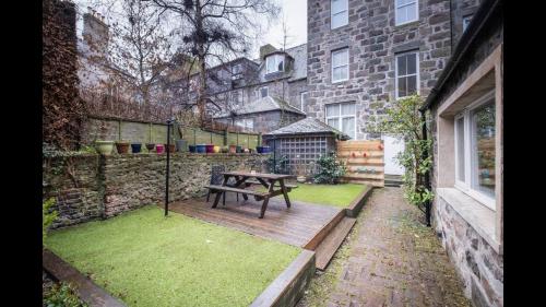 a patio with a picnic table in a yard at The Cottage in Aberdeen