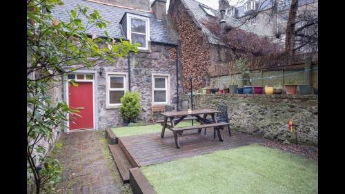 a wooden deck with a picnic table in front of a house at The Cottage in Aberdeen