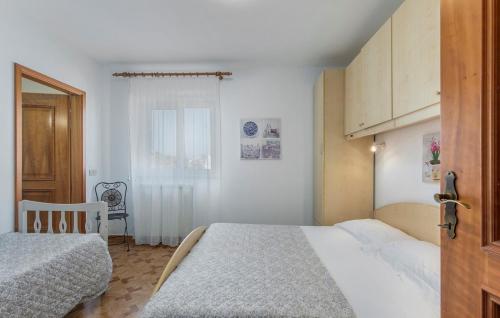 een slaapkamer met 2 bedden en een tafel en een stoel bij Apartment Complex Orzan Lovrecica in Umag