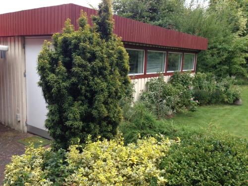 une maison avec un grand bush devant elle dans l'établissement Risskov Bellevue Guesthouse, à Aarhus