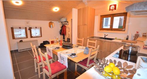 cocina con mesa y sillas en Chalet Rouge Coeur, en Fenalet Sur Bex