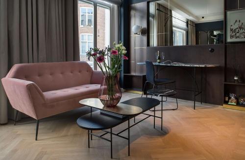 salon z różową kanapą i stołem z kwiatami w obiekcie Spinoza Suites w Amsterdamie