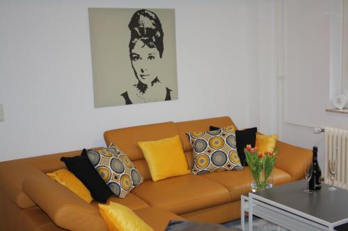 a living room with a brown couch with yellow pillows at Schöne 60qm große Wohnung Mainz-Lerchenberg ZDF in Mainz