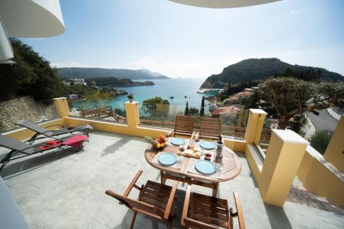 een tafel en stoelen op een balkon met uitzicht op de oceaan bij Barbara's House in Paleokastritsa