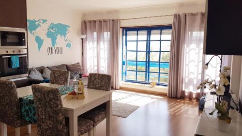 uma sala de estar com um sofá, uma mesa e uma janela em Magoito Sea View Apartment em Lisboa