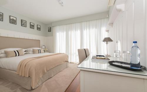 een witte slaapkamer met een bed en een glazen tafel bij Cascais Casa Laranja in Cascais