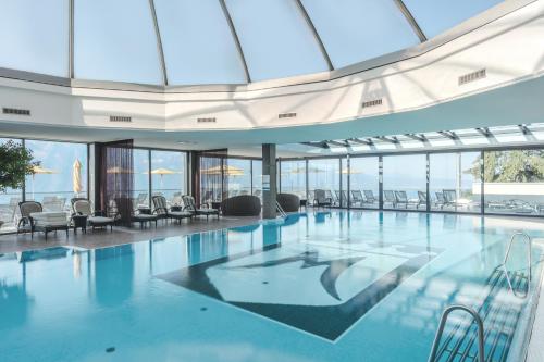 duży basen z krzesłami i oknami w obiekcie Le Mirador Resort & Spa w mieście Vevey