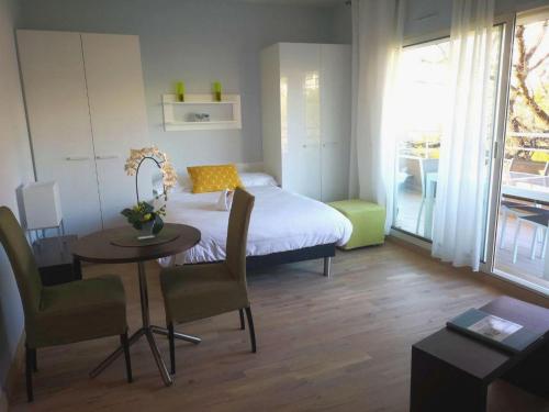 Schlafzimmer mit einem Bett, einem Tisch und Stühlen in der Unterkunft Arthur Properties Bel Air in Cannes