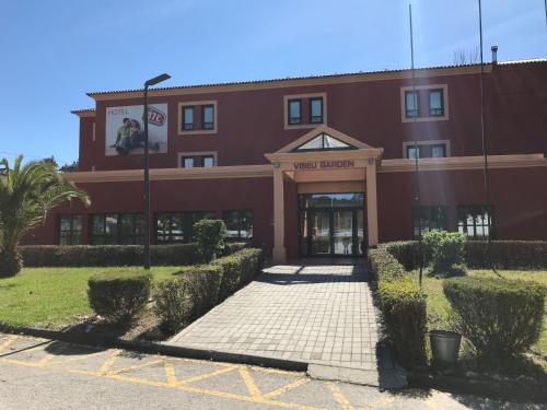 ein rotes Gebäude mit Straßenbeleuchtung davor in der Unterkunft Viseu Garden Hotel in Viseu