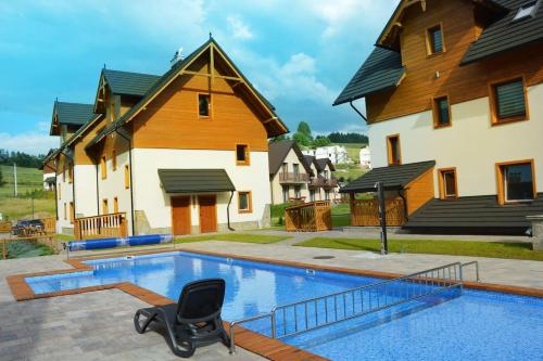 una piscina con una sedia di fronte a una casa di Przystań Góralska a Szczawnica