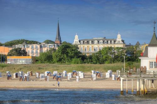 plaża z leżakami i parasolami na brzegu w obiekcie SEETELHOTEL Ostseehotel Ahlbeck w mieście Ahlbeck