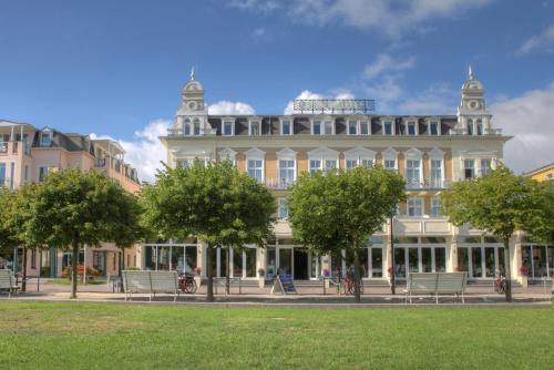 duży biały budynek z drzewami przed nim w obiekcie SEETELHOTEL Ostseehotel Ahlbeck w mieście Ahlbeck