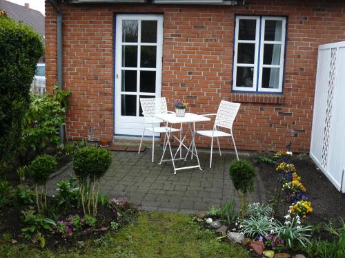 een patio met een tafel en stoelen voor een bakstenen huis bij Ferienwohnung Seidler in Rendsburg