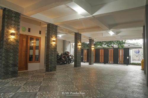 een lobby van een gebouw met zuilen en motorfietsen bij M Stay Guest House Jogja in Yogyakarta