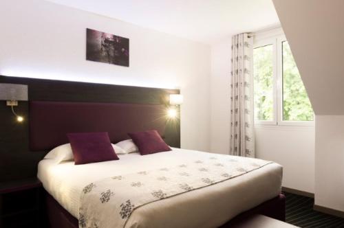 A bed or beds in a room at The Originals City Hôtel, Aéroport Beauvais