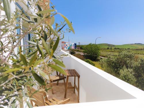 balcone con 2 sedie e un tavolo di Pure Fonte Velha B&B a Vila do Bispo