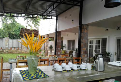 uma mesa com um vaso com flores amarelas em Urban Lodge em Bujumbura