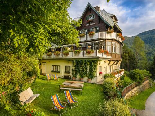 duży dom z krzesłami i ogrodem w obiekcie Villa Daheim Semmering w mieście Semmering