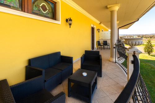 - une terrasse couverte avec 2 canapés, une table et des chaises dans l'établissement Hotel Lido - Beach and Palace, à Bolsena