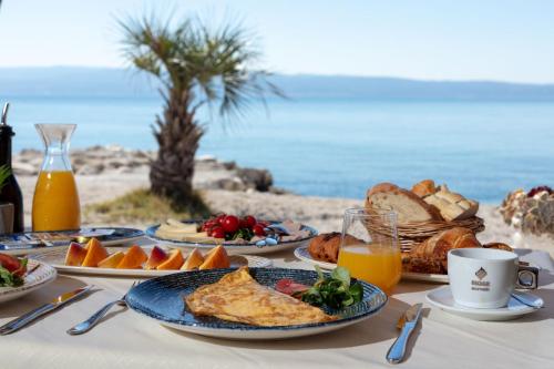 stół z talerzami jedzenia na plaży w obiekcie Luxury Villa Karla w Podstranie