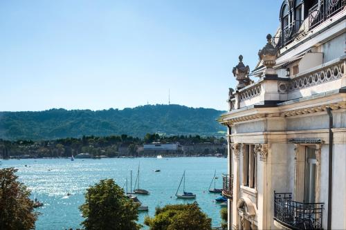 een gebouw met uitzicht op een waterlichaam met boten bij La Réserve Eden au Lac Zurich in Zürich