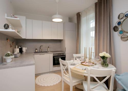 uma cozinha com uma mesa e cadeiras e uma cozinha com uma mesa e uma cozinha em Modern quiet 2 bedroom apartment near City center em Pärnu