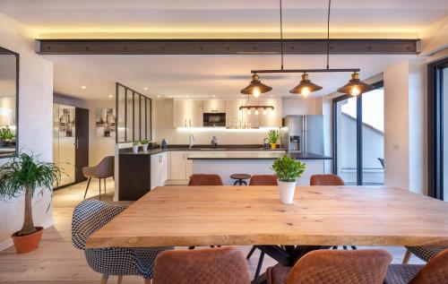 une cuisine ouverte et une salle à manger avec une table et des chaises en bois dans l'établissement Residence Provencal - Luxurious - 300m Palais - LRA CANNES, à Cannes