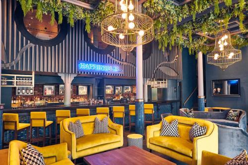 Malmaison Belfast في بلفاست: مطعم وكراسي صفراء وبار