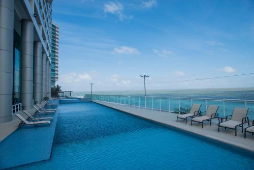 d'un balcon avec des chaises et une piscine. dans l'établissement Hotel Luzeiros São Luis, à São Luís