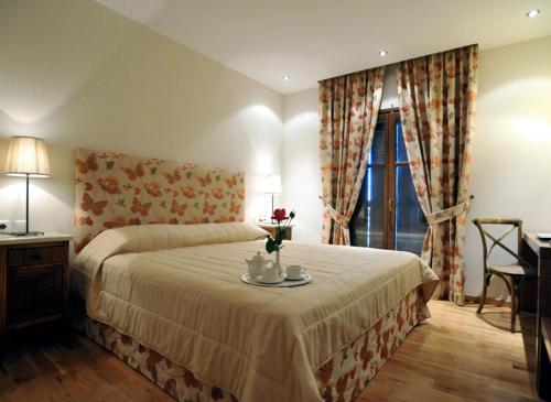 a bedroom with a bed and a table with flowers on it at Boutique Hotel Kentrikon & Bungalows in Agios Ioannis Pelio