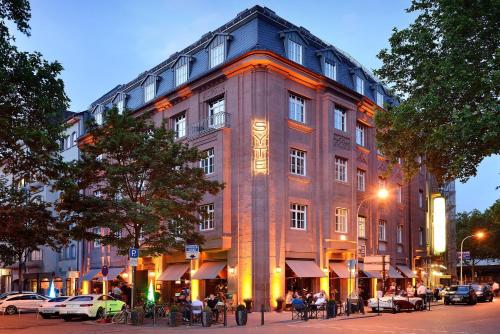 ein großes Gebäude mit Leuten, die draußen sitzen in der Unterkunft Syte Boutique Hotel Mannheim in Mannheim