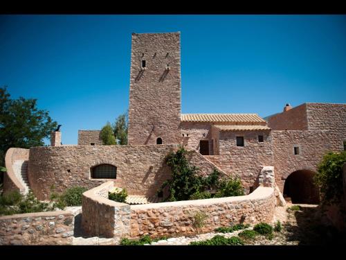 a large stone building with a clock tower at Arapakis Historic Castle in Pirgos Dhirou